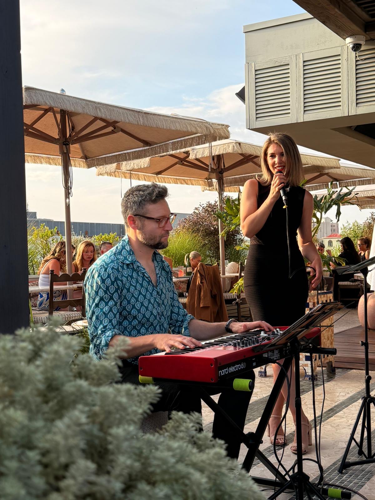 Ivett Karasz cantando en una terraza con pianista